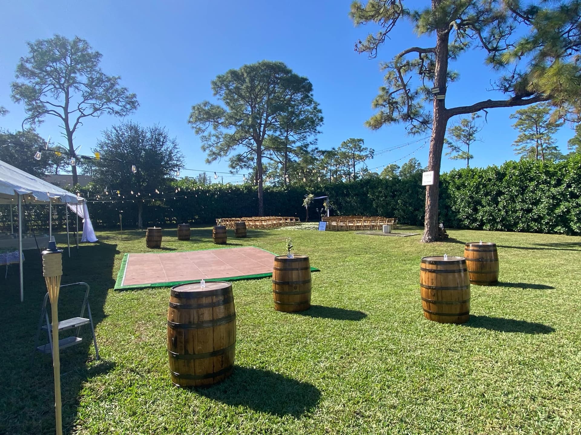 Whiskey barrels arranged across a lawn for an outdoor wedding